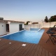 beautiful swimming pool with wooden deck by the house