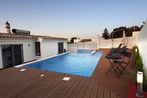 beautiful swimming pool with wooden deck by the house